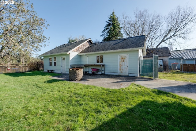 878 NW Warrenton Dr, Warrenton, OR 97146 - rear view of house with a gate, a shingled roof, a yard, and fence