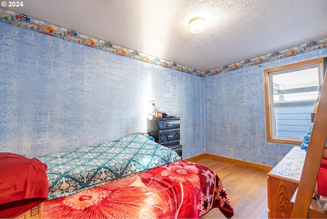 111 N Trade St, Amity, OR 97101 - bedroom with a textured ceiling, wood finished floors, baseboards, and wallpapered walls