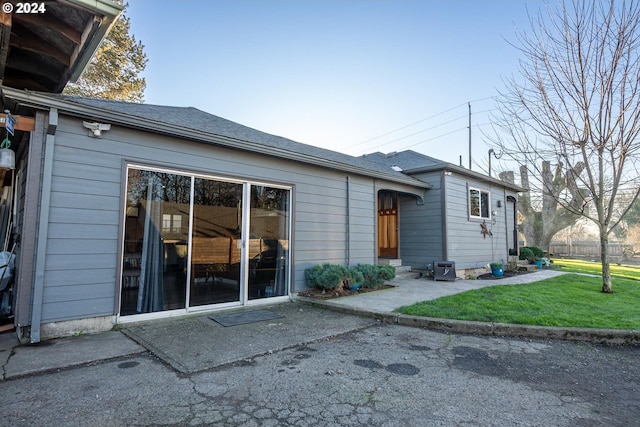 back of house with a patio and a lawn