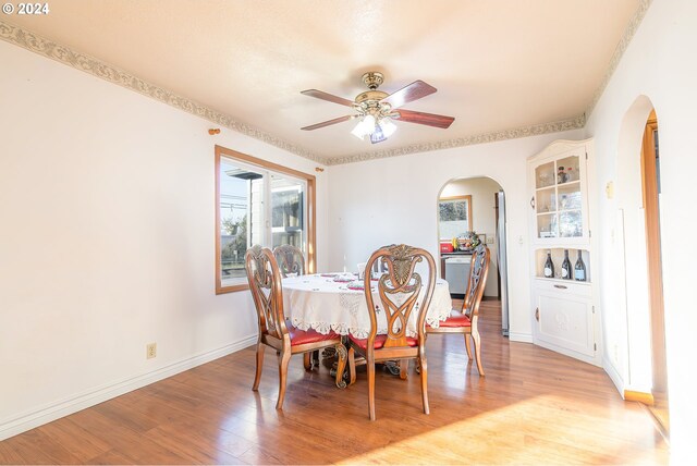 111 N Trade St, Amity, OR 97101 - dining room with arched walkways, baseboards, a ceiling fan, and light wood-style floors