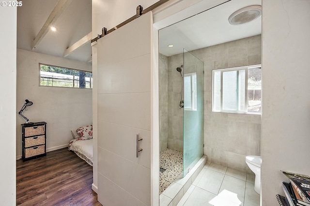 bathroom with lofted ceiling with beams, toilet, wood finished floors, and a shower stall