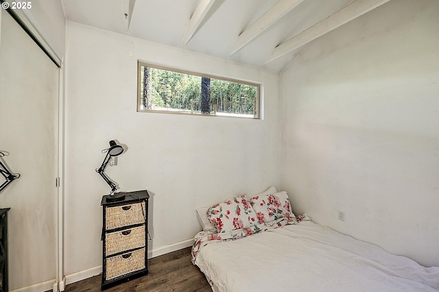 bedroom featuring lofted ceiling with beams, baseboards, and dark wood-style flooring