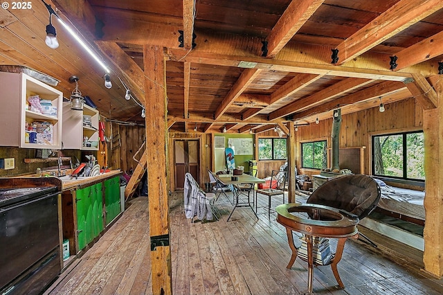 interior space with wooden walls, beamed ceiling, and wood-type flooring