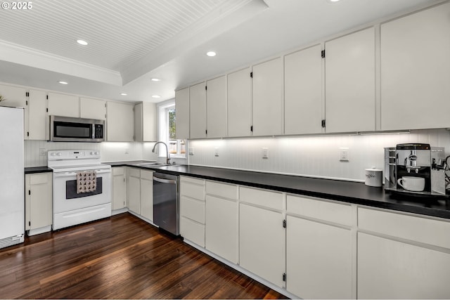 117 E Cushman St, Yacolt, WA 98675 - kitchen with stainless steel appliances, a sink, a tray ceiling, recessed lighting, and dark wood-style flooring
