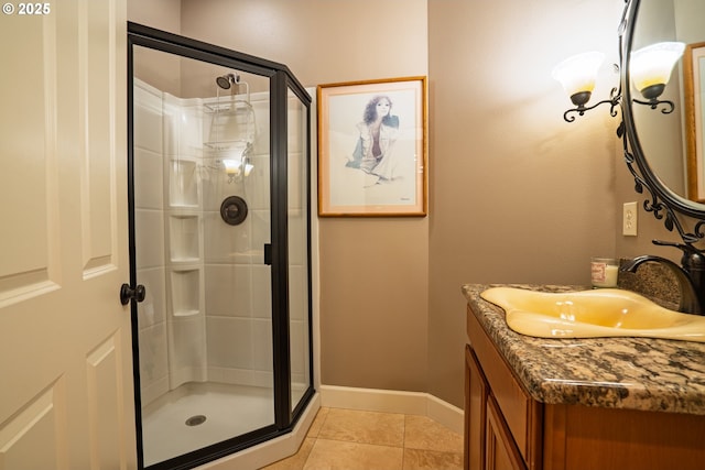 bathroom featuring a shower stall, baseboards, tile patterned floors, and vanity