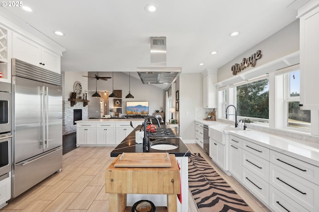 20265 SE Poco Ln, Amity, OR 97101 - kitchen featuring stainless steel appliances, a stone fireplace, tasteful backsplash, white cabinetry, and recessed lighting