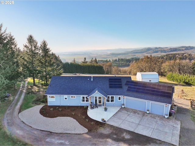 20265 SE Poco Ln, Amity, OR 97101 - view of front of house featuring driveway, roof mounted solar panels, a shingled roof, and a garage
