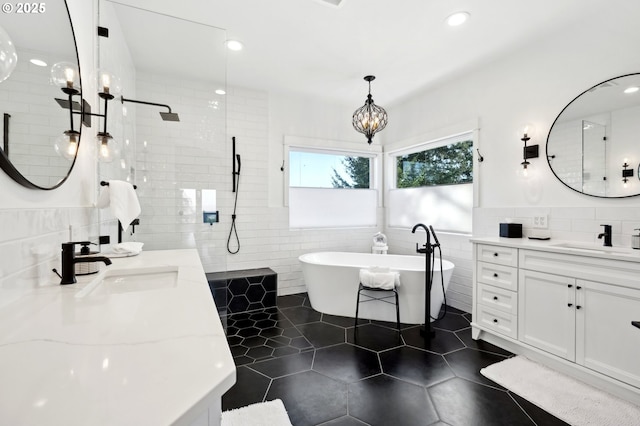 20265 SE Poco Ln, Amity, OR 97101 - full bath featuring tile walls, tile patterned floors, a freestanding bath, two vanities, and a chandelier