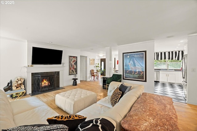 living room featuring sink, crown molding, and wood-type flooring