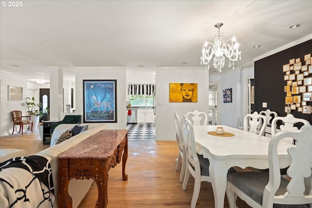 dining room featuring crown molding, light hardwood / wood-style floors, and a notable chandelier