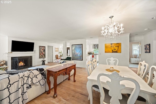 dining area featuring crown molding, an inviting chandelier, and light hardwood / wood-style floors