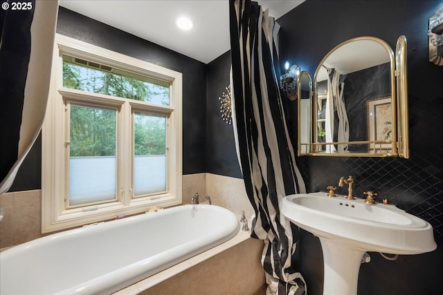 bathroom with a relaxing tiled tub and tasteful backsplash