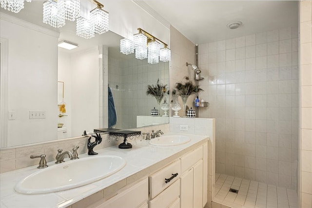 bathroom featuring tiled shower, vanity, ornamental molding, and a notable chandelier