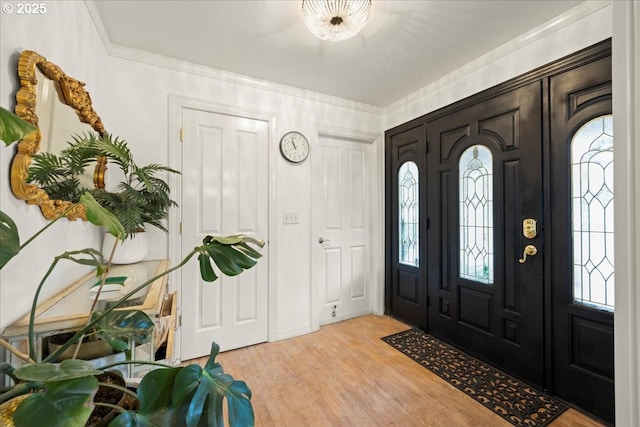 foyer with crown molding and light wood-type flooring