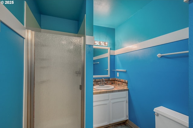 bathroom with vanity, an enclosed shower, and toilet