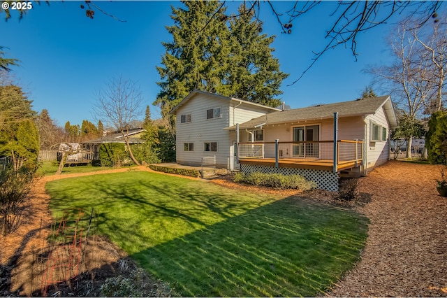 back of property with a deck and a lawn