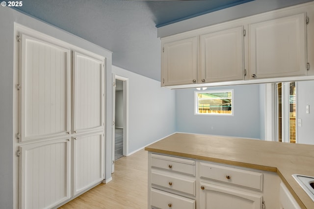 kitchen with white cabinetry and light wood-type flooring