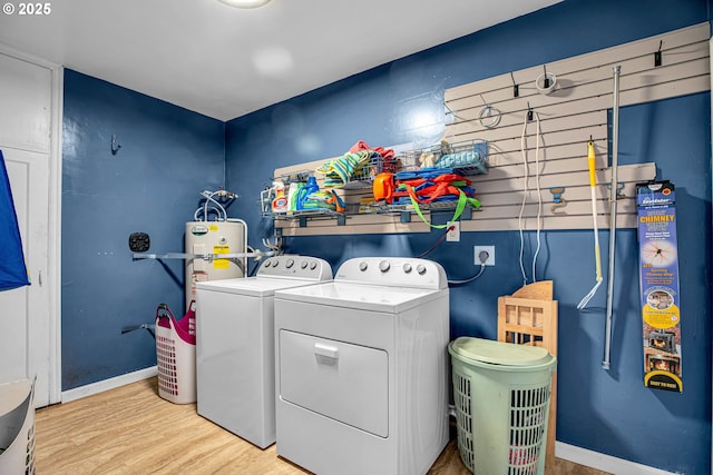 laundry area with washing machine and clothes dryer and light wood-type flooring