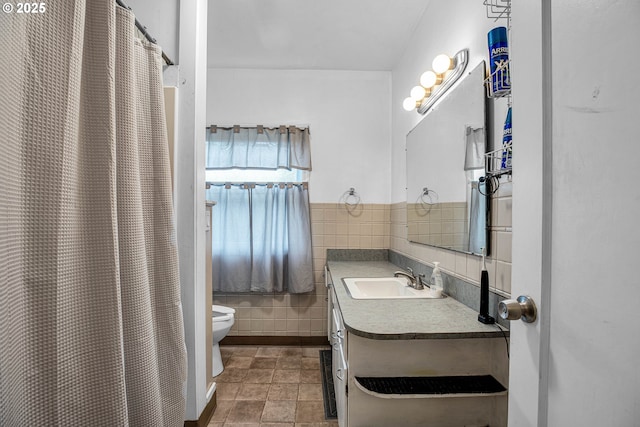 bathroom with tile walls, tile patterned flooring, vanity, walk in shower, and toilet