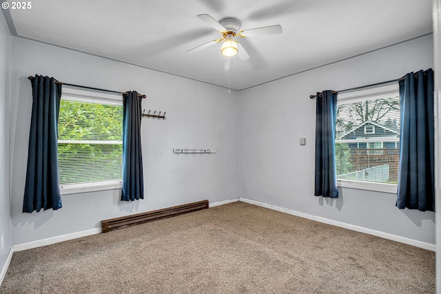 carpeted spare room with a wealth of natural light, ceiling fan, and baseboard heating