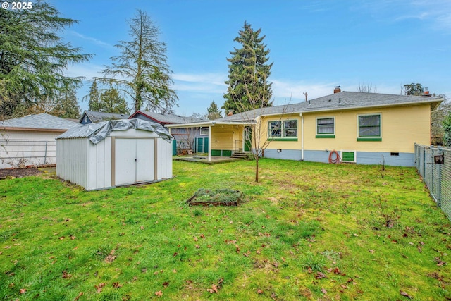 rear view of house featuring a storage shed and a lawn