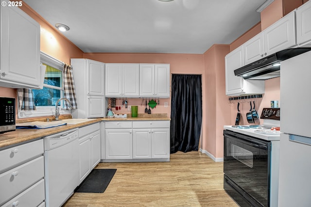 kitchen with sink, white appliances, white cabinets, and light wood-type flooring