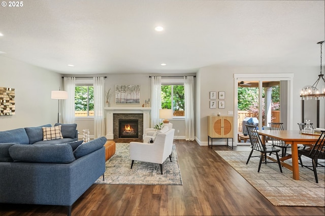3466 N Holladay St, Cornelius, OR 97124 - living area featuring healthy amount of natural light, dark wood-type flooring, a lit fireplace, recessed lighting, and a chandelier