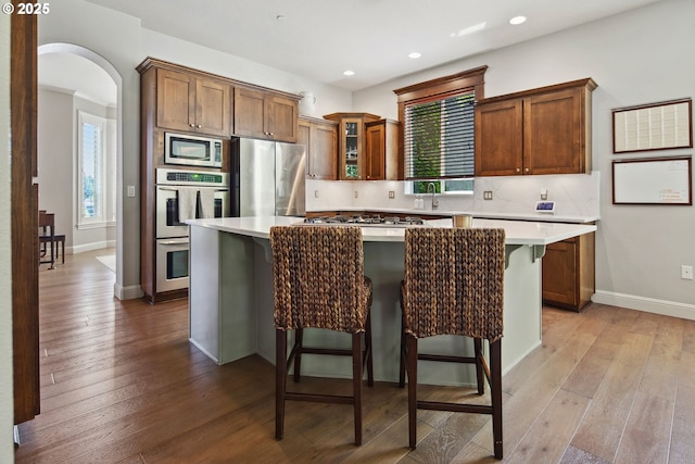 3534 NW Maple St, Camas, WA 98607 - kitchen featuring stainless steel appliances, arched walkways, a center island, plenty of natural light, and recessed lighting