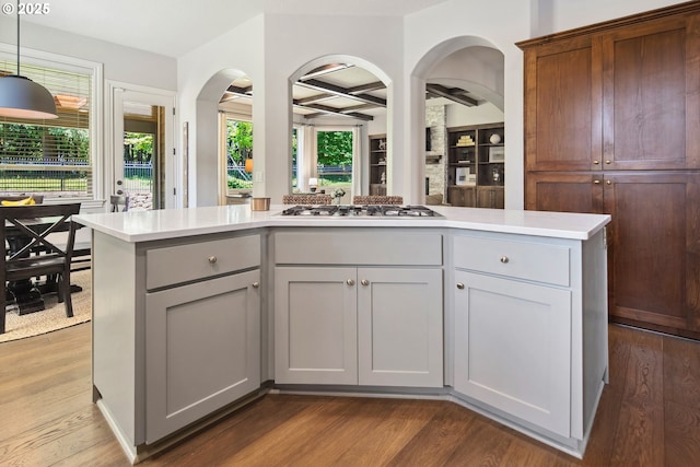 3534 NW Maple St, Camas, WA 98607 - kitchen featuring stainless steel gas cooktop, dark wood-type flooring, light countertops, arched walkways, and healthy amount of natural light
