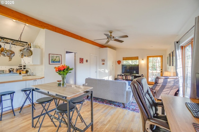 living room featuring lofted ceiling with beams, sink, ceiling fan, and light hardwood / wood-style flooring