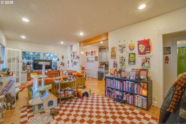 playroom featuring light hardwood / wood-style floors and a textured ceiling