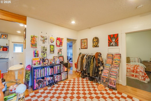 rec room featuring light hardwood / wood-style flooring and a textured ceiling