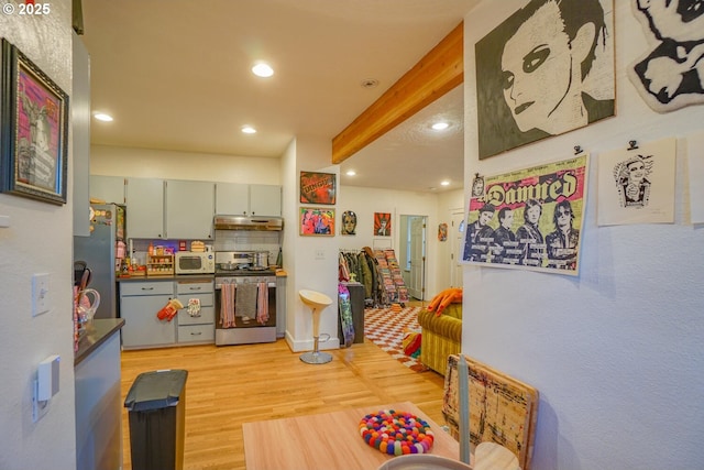 kitchen featuring tasteful backsplash, appliances with stainless steel finishes, and light wood-type flooring