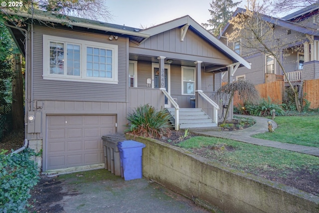 view of front of house featuring a garage, a front yard, and a porch