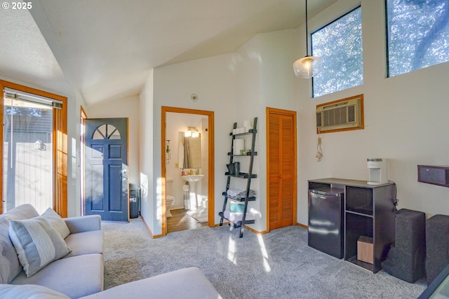 carpeted living room with an AC wall unit and high vaulted ceiling