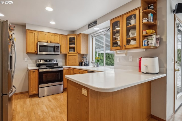 16111 NW Paisley Dr, Beaverton, OR 97006 - kitchen featuring stainless steel appliances, a peninsula, recessed lighting, light wood finished floors, and light countertops