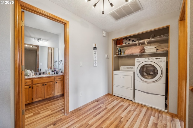 16111 NW Paisley Dr, Beaverton, OR 97006 - washroom with light wood-style floors, washer and dryer, and a textured ceiling