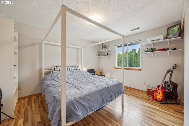 16111 NW Paisley Dr, Beaverton, OR 97006 - bedroom with a textured ceiling, wood finished floors, and an AC wall unit