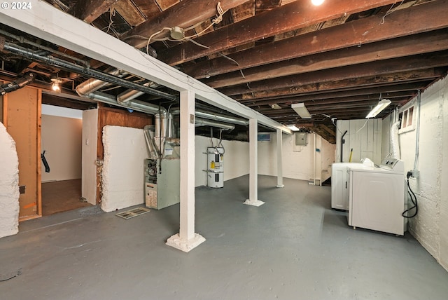 basement with washing machine and dryer, heating unit, secured water heater, and electric panel