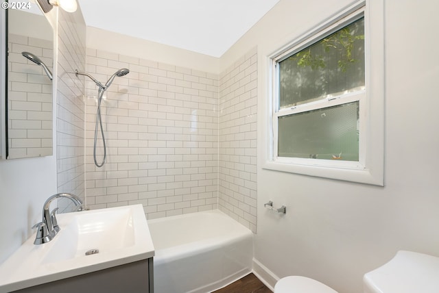 full bathroom featuring sink, wood-type flooring, toilet, and tiled shower / bath