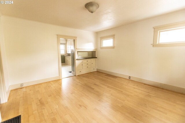 interior space with a skylight, high vaulted ceiling, visible vents, and light wood-type flooring