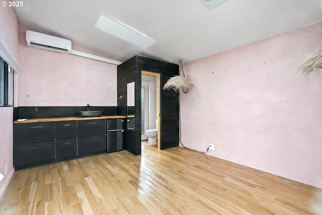 empty room featuring light wood finished floors, visible vents, and baseboards