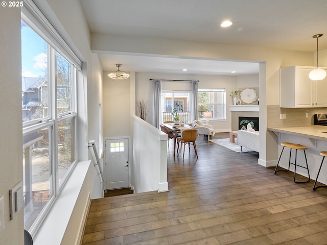 foyer with recessed lighting, a fireplace, dark wood finished floors, and baseboards