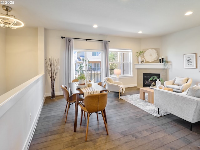 sitting room featuring baseboards, a glass covered fireplace, dark wood-type flooring, and recessed lighting