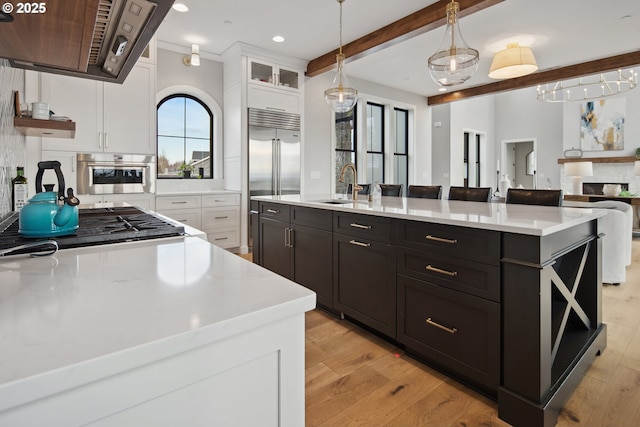 14014 NW 57th Ave, Vancouver, WA 98685 - kitchen with range hood, light wood finished floors, stainless steel appliances, white cabinetry, and a sink