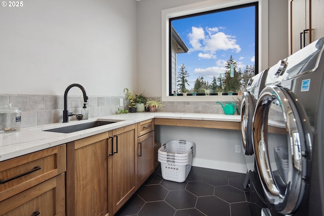 14014 NW 57th Ave, Vancouver, WA 98685 - laundry room featuring dark tile patterned flooring, washing machine and clothes dryer, cabinet space, and a sink