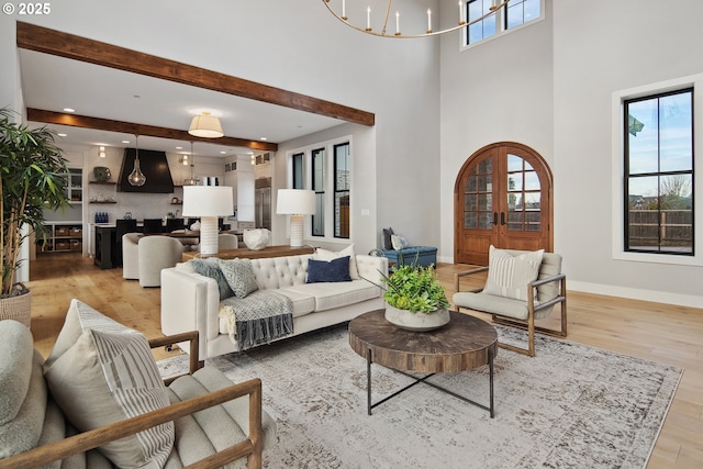 14014 NW 57th Ave, Vancouver, WA 98685 - living room featuring baseboards, a towering ceiling, beam ceiling, light wood-style floors, and a notable chandelier