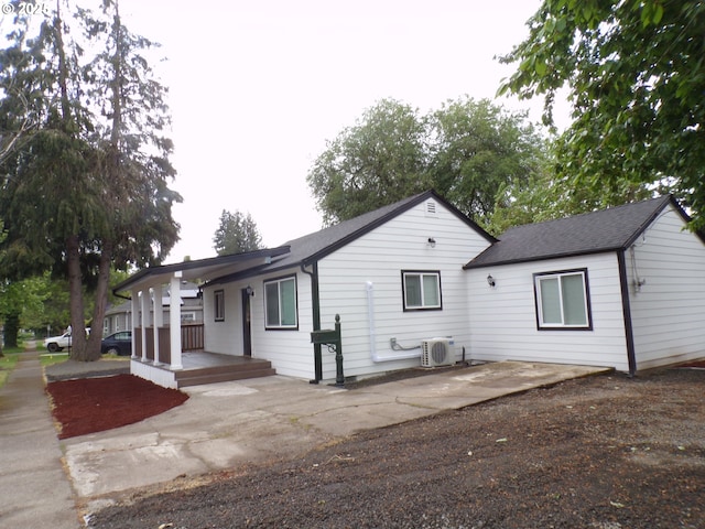 870 W Lincoln St, Woodburn, OR 97071 - view of front of house featuring roof with shingles, ac unit, a porch, a patio area, and a carport