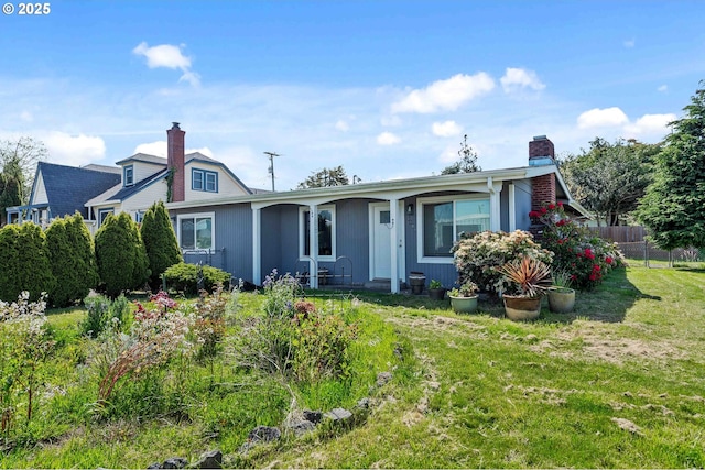 view of front of property with fence, a chimney, and a front lawn
