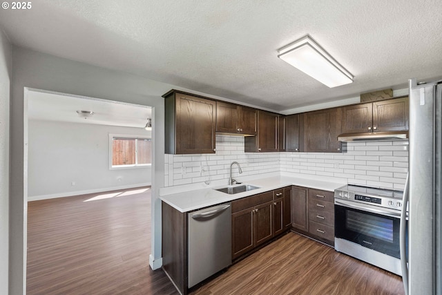 kitchen featuring dark wood-type flooring, a sink, dark brown cabinets, and stainless steel appliances